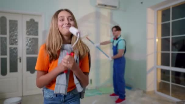 Fröhliches Teenie Mädchen Mit Farbroller Das Tanzt Während Ein Verschwommener — Stockvideo