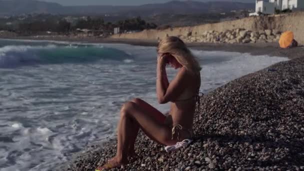 Vista Lateral Mulher Bronzeada Magro Colocando Óculos Sol Sentado Praia — Vídeo de Stock