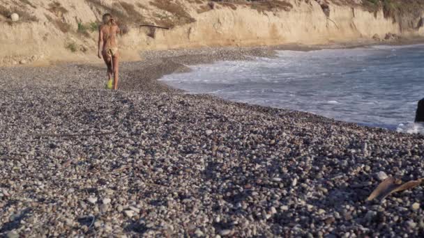 Широкий Снимок Назад Вид Стройная Женщина Идущая Солнечному Галечному Пляжу — стоковое видео