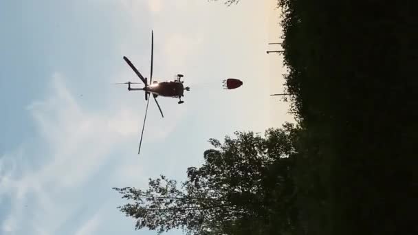 Vertikale Video Silhouette Eines Feuerwehrhubschraubers Sonnenuntergang Der Wasser Aus Einem — Stockvideo