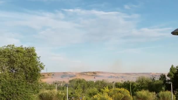 在西班牙 春天的高山上 消防直升机在烟雾中掠过 射得很宽 阳光明媚的日子里 消防队员在室外用斩草刀扑灭大火 生态和应急概念 — 图库视频影像