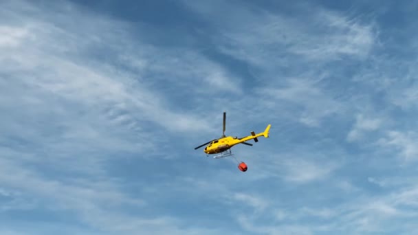 マドリード スペイン 2023年5月16日 日没時に貯水池へ飛ぶ赤いチョッパーに青い空を通過する黄色い消防ヘリコプターを追跡するライブカメラ 屋外で消火する航空機 — ストック動画