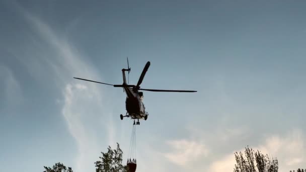 석양에서 수지로 날아들어 소방용 헬리콥터 실루엣 가지면 밖에서 소화기용 모으고 — 비디오