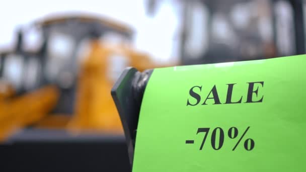 Nahaufnahme Rabattankündigung Mit Verschwommenen Gelben Riesigen Traktoren Hintergrund Großaufnahme Verkauf — Stockvideo