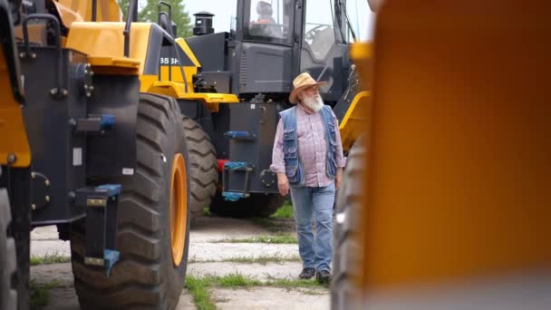 Portrait Large Agriculteur Expert Réfléchi Marchant Entre Des Rangées Tracteurs — Video