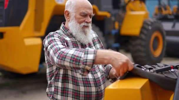 专注的资深维修工程师从工具包中取出扳手 在室外修理巨大的拖拉机 专业白种人修理破碎农用车辆的肖像 — 图库视频影像