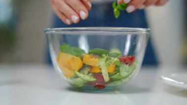 Yakından tanınmayan genç bir kadın yeşil yaprakları salata kasesine yerleştiriyor ve yavaş çekimde lezzetli bir akşam yemeğiyle ayrılıyor. Kafkasyalı ev hanımı, içeride lezzetli yemekler yiyor.