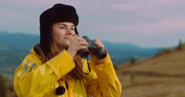 Mujer Joven Sonriente Mirando Hacia Otro Lado Con Prismáticos Saludando — Vídeo de stock
