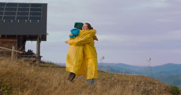 Duas Mulheres Felizes Casacos Chuva Amarelos Abraçando Câmera Lenta Pico — Vídeo de Stock