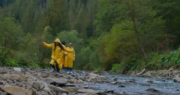 Grupo Excursionistas Abrigos Lluvia Amarillos Caminando Cámara Lenta Sobre Rocas — Vídeo de stock