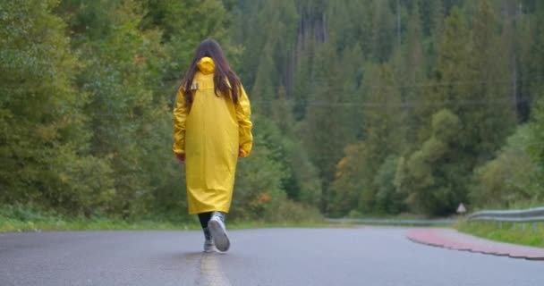 Vista Posterior Mujer Joven Tiro Ancho Abrigo Lluvia Amarillo Caminando — Vídeo de stock