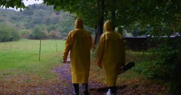 Duas Mulheres Casacos Chuva Amarelos Andando Prado Floresta Montanhas Vista — Vídeo de Stock