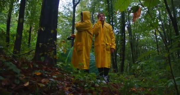 Twee Vrolijke Jonge Vrouwen Die Gele Regenjassen Bij Tent Staan — Stockvideo