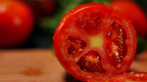 熟した赤いトマトの半分のクローズアップパンニングショット 木のテーブルの上でおいしい有機野菜を屋内で閉じます — ストック動画