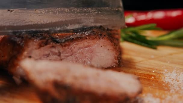 キッチン斧でまな板においしいジューシーなステーキをスライスクローズアップ 遅い動きでおいしい肉を切断閉じる — ストック動画