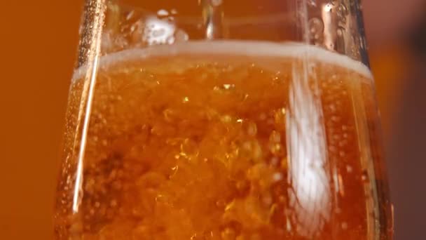 Birra Close Bollente Versando Vetro Trasparente Sfondo Arancione Primo Piano — Video Stock