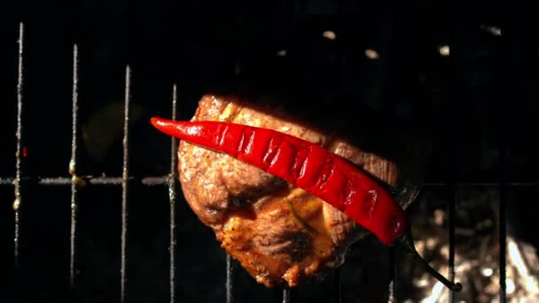 顶部是烤牛排上的辣椒 影子慢动作地移开 烤架上的特写美味多汁肉类和红色蔬菜 — 图库视频影像