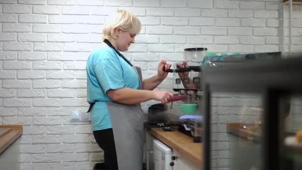 侧视积极的女人在室内咖啡店清洁咖啡壶 在城市的咖啡店里 白种人的女咖啡师正在准备美味的热饮 — 图库视频影像