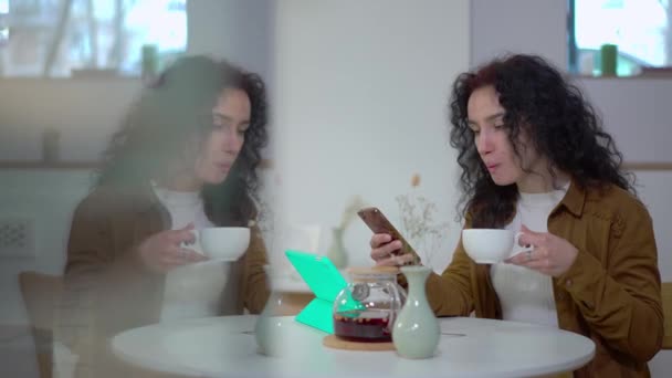 Белая Молодая Женщина Пьет Чай Через Интернет Приложении Смартфонов Отражаясь — стоковое видео