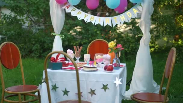 Geschmückter Picknicktisch Park Mit Fröhlichen Kindern Die Lächelnd Auf Stühlen — Stockvideo