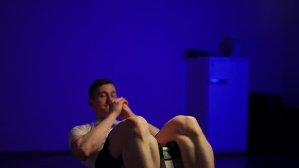 聚精会神的年轻运动员在蓝色体育馆里做仰卧起坐的画像 有动力的白种人英俊男子在室内锻炼 — 图库视频影像