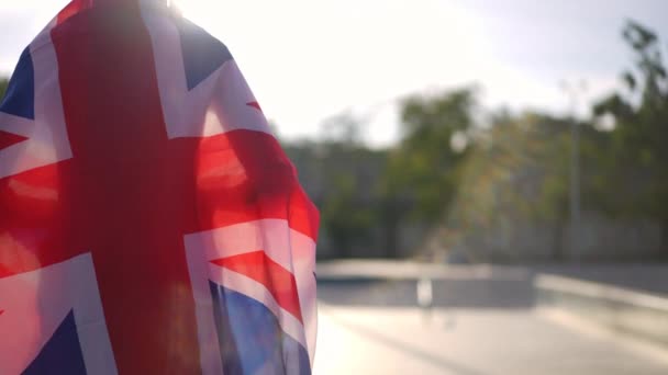 Vue Dos Adolescent Méconnaissable Enveloppé Dans Drapeau Britannique Cheval Planche — Video