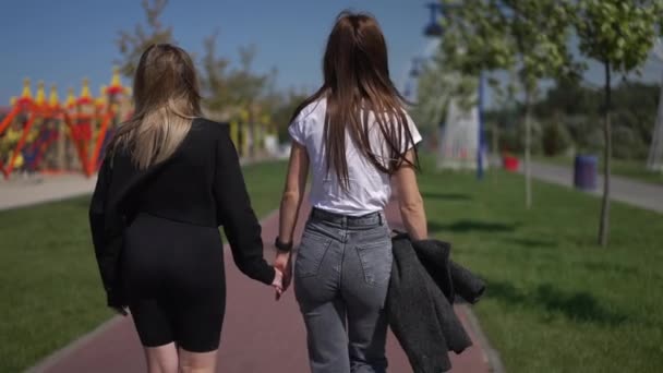 Back View Young Women Holding Hands Strolling Slow Motion One — Stock Video
