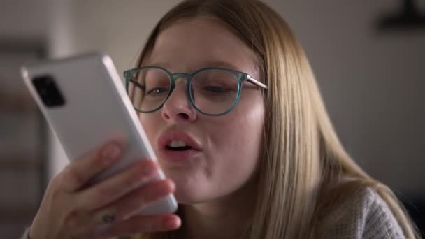 ゆっくりとした動きでスピーカーフォンでしゃべっている怒っている若い不満の女性 スマートフォンで主張する激怒する神経白人女性のクローズアップ肖像画 — ストック動画