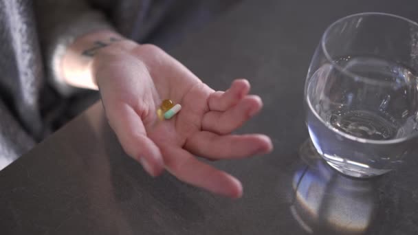 水のガラスが付いている錠剤が付いているクローズアップ揺れる女性のパーム ゆっくりとした動きで残る抗うつ薬を有する認識できない高角度ビューを閉じる — ストック動画