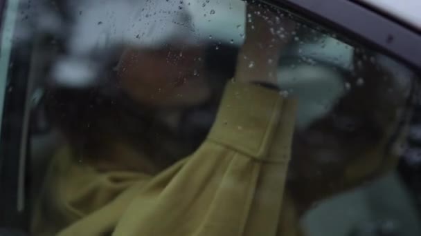 闭合车窗 雨滴和模糊的年轻女子在背景下慢动作地调整化妆 无法辨认的白人女士坐在车上的乘客座位上 — 图库视频影像