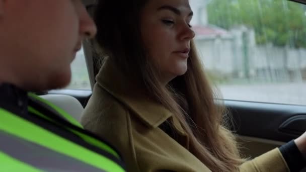 坐在驾驶座上与男性交谈的积极的年轻女性的侧视图画像 自信的白人女学生从开车的专家那里学习开车 — 图库视频影像