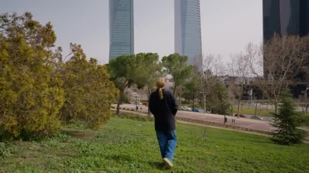 Rückansicht Weitwinkel Freudige Frau Die Auf Grünem Rasen Städtischen Wolkenkratzern — Stockvideo