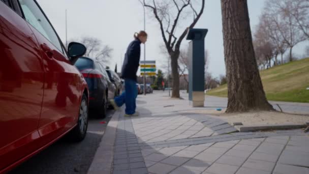 駐車場のメーターの支払いに歩いている ぼやけた自信のある女性との歩道舗装 ブロンド白人女性ドライバー 屋外の都市の駐車場マシンを使用して — ストック動画