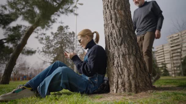 Donna Spensierata Seduta Con Smartphone Sul Prato Verde Come Uomo — Video Stock