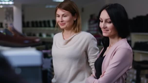 Två Vackra Vuxna Kvinnor Tittar Runt Och Väljer Nya Skor — Stockvideo