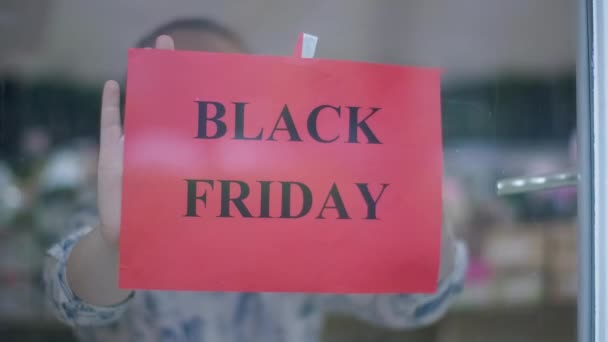 Mulher Desfocada Atrás Vidro Colocando Anúncio Black Friday Vitrine Ireconhecível — Vídeo de Stock