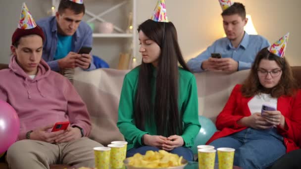 パーティーの若い女性は 携帯電話でソーシャルメディアアプリをスクロールする友人がポケットからスマートフォンを奪うのを嫌う 現代のインターネット中毒の概念 — ストック動画