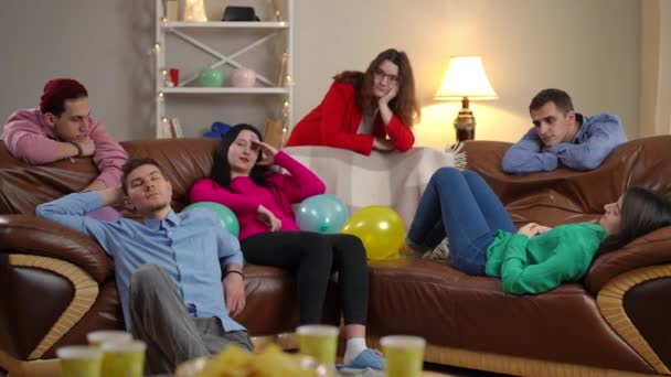 Große Gruppe Gelangweilter Junger Männer Und Frauen Wohnzimmer Drinnen Unachtsame — Stockvideo
