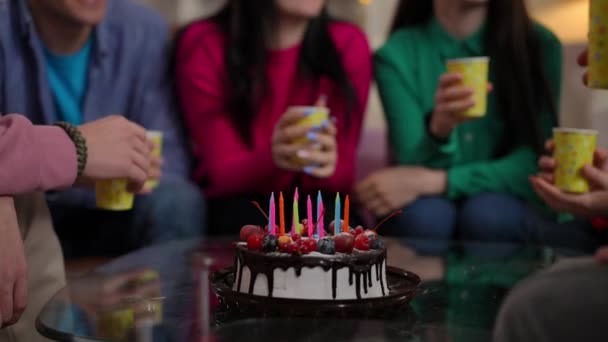 与一群年轻人一起在桌上享用特写美味的甜蛋糕 他们的蛋糕上还烤着叮当声的纸杯 难以辨认的白人男女在室内庆祝派对 — 图库视频影像