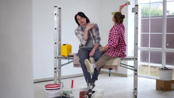 Podekscytowana Kobieta Mówiąca Wizji Renowacji Salonu Znudzonemu Mężczyźnie Siedzącemu Żoną — Wideo stockowe
