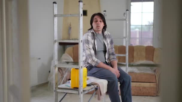 Retrato Hombre Cansado Sentado Una Casa Nueva Reparación Como Una — Vídeo de stock
