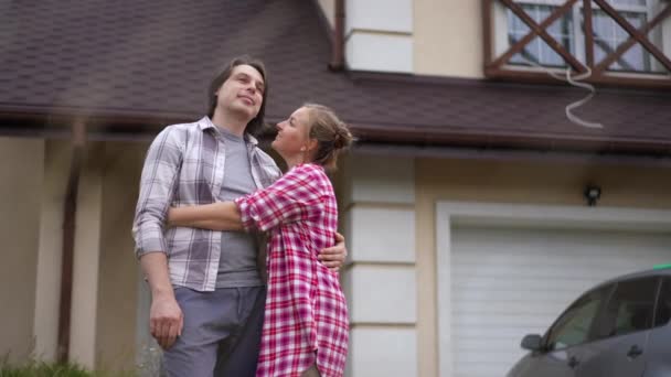 Gelukkig Knuffelende Echtpaar Aan Linkerkant Achtergrond Van Nieuw Huis Buiten — Stockvideo