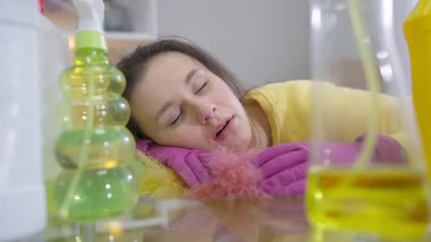 疲れた若い女性は洗剤を洗浄するテーブルで昼寝をする 疲れたコーカサス人の美しい主婦の肖像画 屋内で自宅で寝る — ストック動画