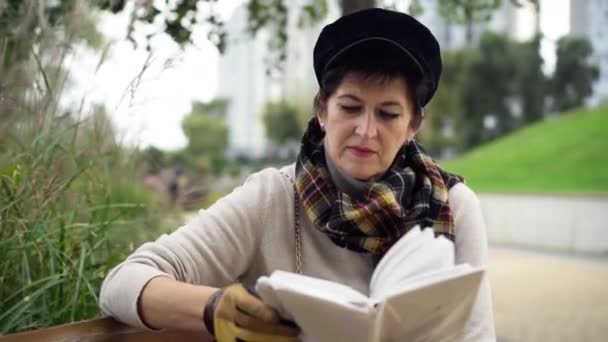 Απορροφημένη Ηλικιωμένη Γυναίκα Διαβάζει Βιβλίο Γυρίζοντας Σελίδα Καθισμένη Στο Πάρκο — Αρχείο Βίντεο