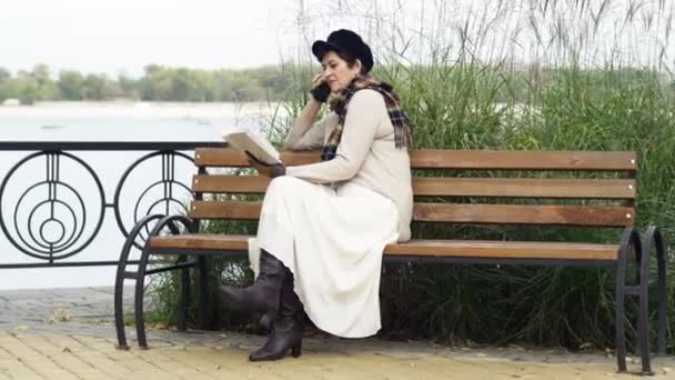 Wide Shot Concentrated Beautiful Senior Woman Reading Book Sitting Bench — Stock Video