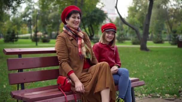 Güzel Büyükanne Torun Bankta Dizlerinin Üstüne Çöküp Kameraya Bakıyorlar Sonbahar — Stok video