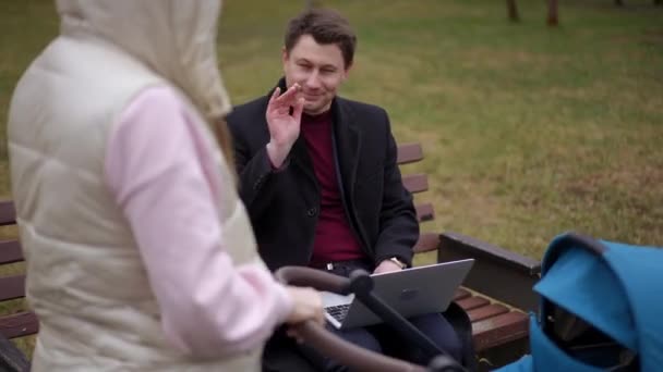 남자는 공원에서 유모차와 떠나는 여자를 인사를 흔들어 벤치에 온라인 메시징 — 비디오