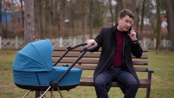 Angry Annoyed Man Talking Phone Sitting Bench Park Shaking Baby — Stock Video