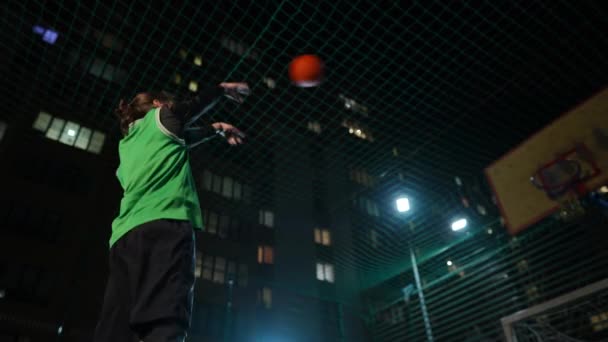 侧角看运动员把球丢进篮网然后离开 适合白人年轻人在夜市户外运动场上玩游戏 — 图库视频影像