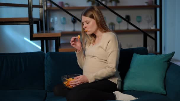 Wanita Hamil Ceroboh Makan Keripik Kentang Duduk Sofa Ruang Tamu — Stok Video